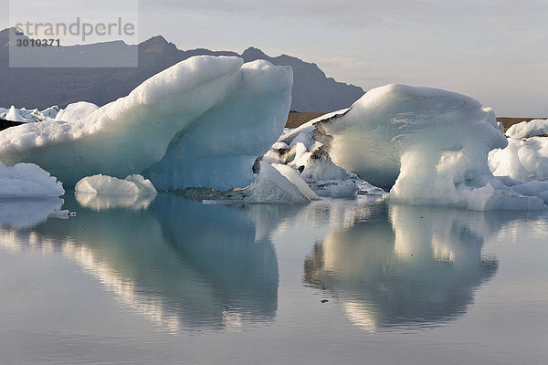 Eisberge deren unterschiedliche Färbung bis hin zu schwarz von Vulkanasche herrührt  Gletschersee Jökulsarlon  Südküste  Island