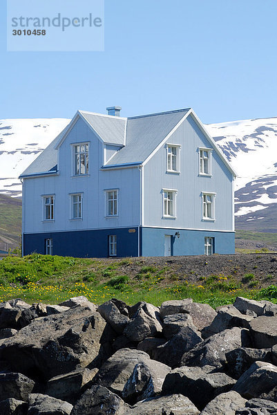 Haus mit schneebedeckten Bergen im Hintergrund  Grenivik  Island  Flachwinkelansicht