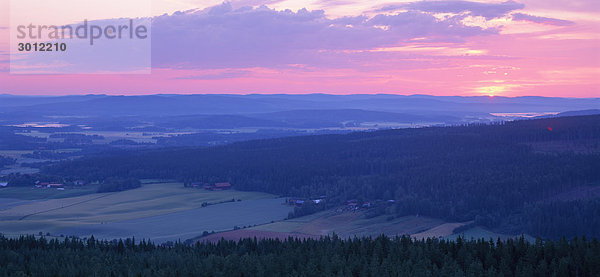 Steigen Sie Sonne über kultiviertem Land.