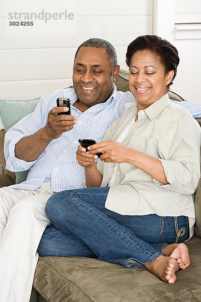 Reife Paare mit Mobiltelefonen