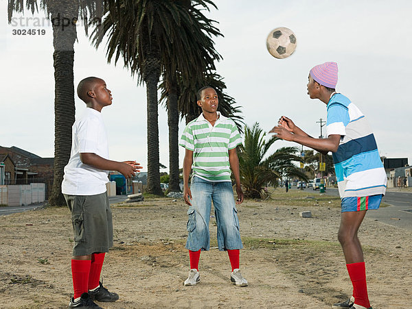 Jungen spielen Fußball auf der Straße