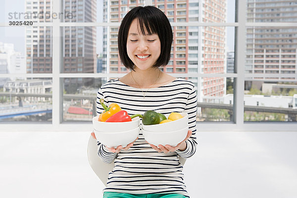 Japanische Frau hält Schalen mit Gemüse