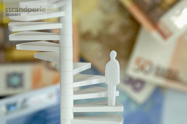 Figurine on spiral stair  money in background