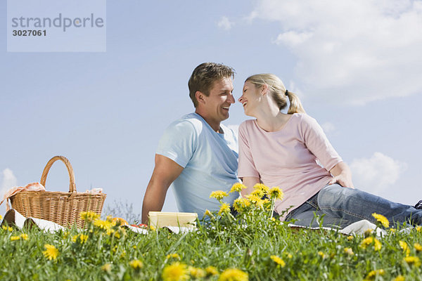 Germany  Bavaria  Munich  Couple having picnic  smiling at each other