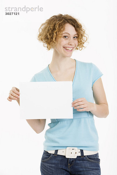Junge Frau hält leeren Karton  lächelnd  Portrait