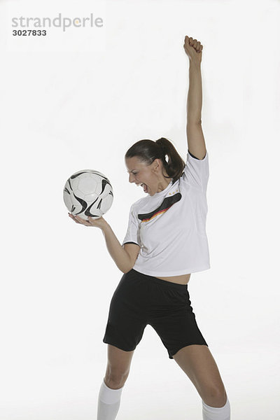 Porträt einer Frau  Fußball haltend  jubelnd