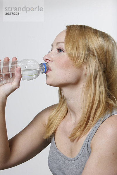 Junge Frau trinkt aus der Wasserflasche  Portrait