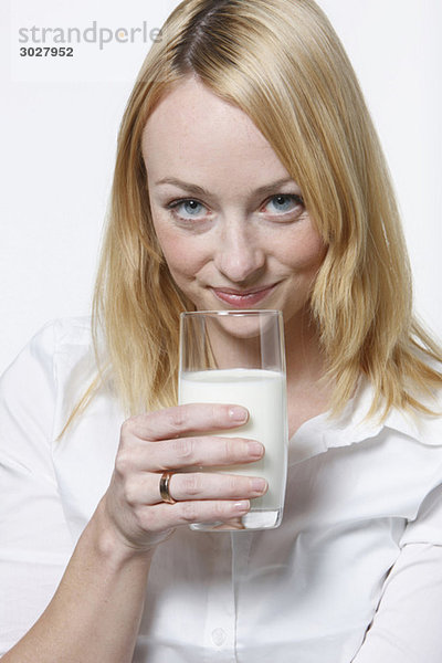 Junge Frau trinkt ein Glas Milch  Portrait
