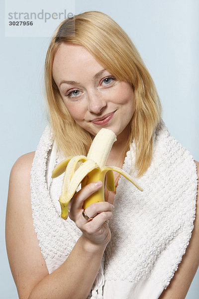 Junge Frau mit Banane  lächelnd  Porträt