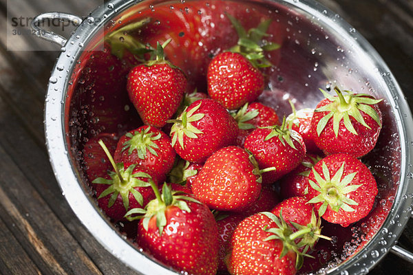 Frische Erdbeeren mit Wassertropfen im Sieb  erhöhte Ansicht