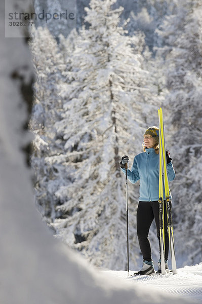 Austria Tyrol  Seefeld  Wildmoosalm  Woman holding cross-country skis