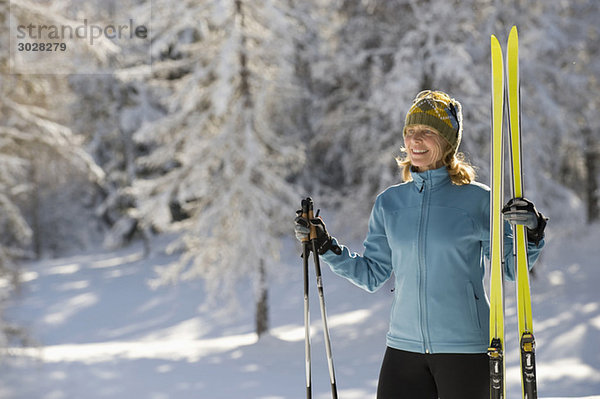 Austria Tyrol  Seefeld  Wildmoosalm  Woman holding cross-country skis