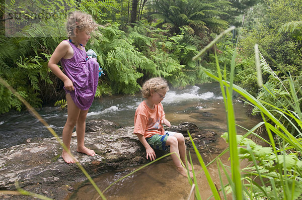 Neuseeland  Rotorua  Kerosene Creek  Zwei Kinder (4-5) (6-7) am Flussufer