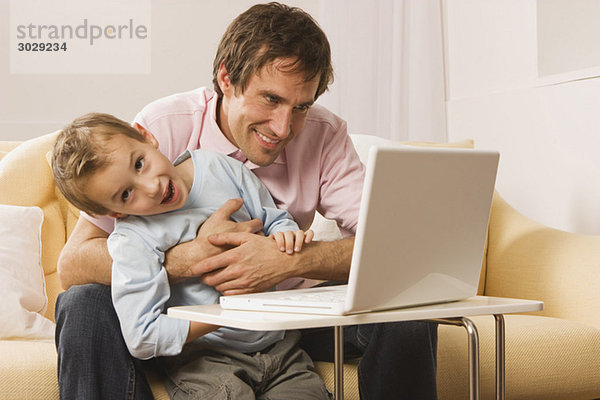 Vater und Sohn (4-5) mit Laptop