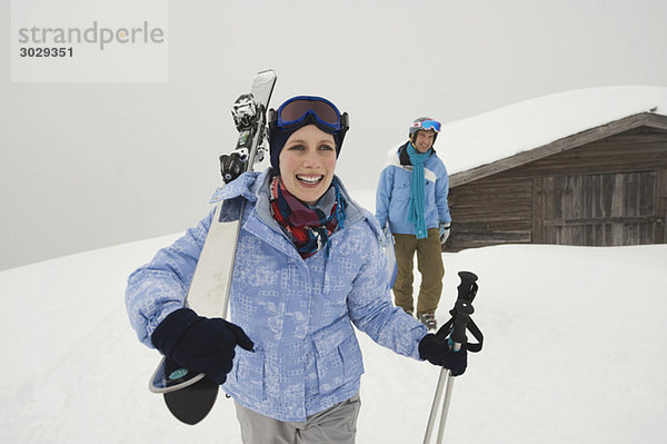 Italien  Südtirol  Junges Paar  Frau mit Skiern über der Schulter