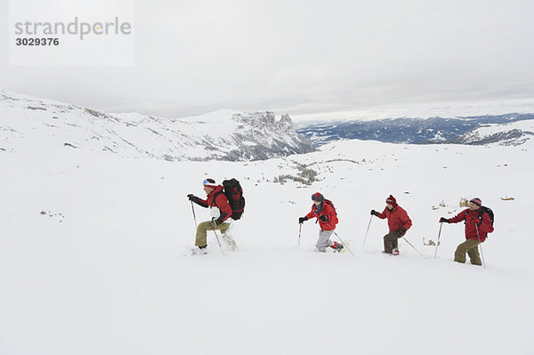 Italien  Südtirol  Vier Personen hintereinander  Schneeschuhwandern
