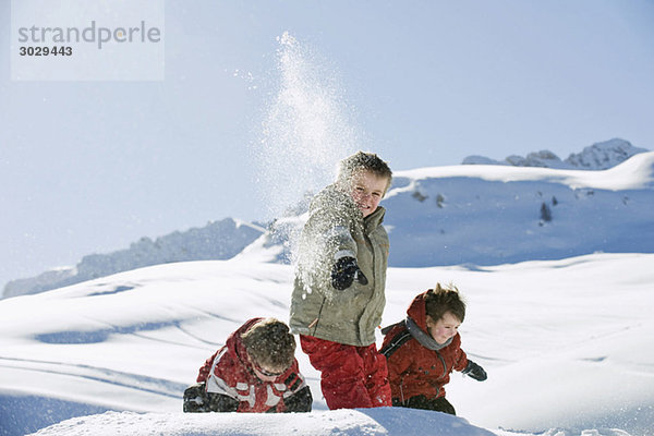 Italien  Südtirol  Seiseralm  Kinder werfen Schnee in die Luft