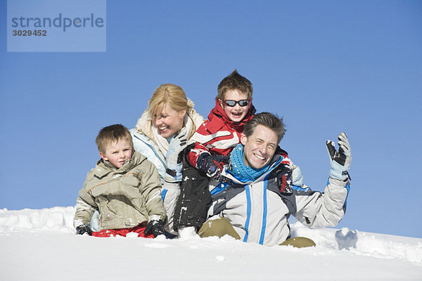 Italien  Südtirol  Seiseralm  Familie im Schnee sitzend  Portrait