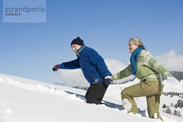 Italien  Südtirol  Seiseralm  Seniorenpaar zu Fuß im Schnee  Seitenansicht  Portrait
