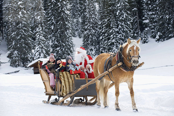 Italien  Südtirol  Seiseralm  Weihnachtsmann und Kinder beim Schlittenfahren