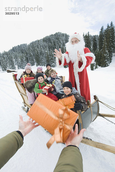 Italien  Südtirol  Seiseralm  Weihnachtsmann und Kinder  Kinder mit Geschenkpaketen