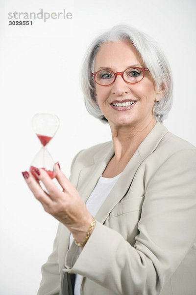 Senior Geschäftsfrau mit Sanduhr  Portrait