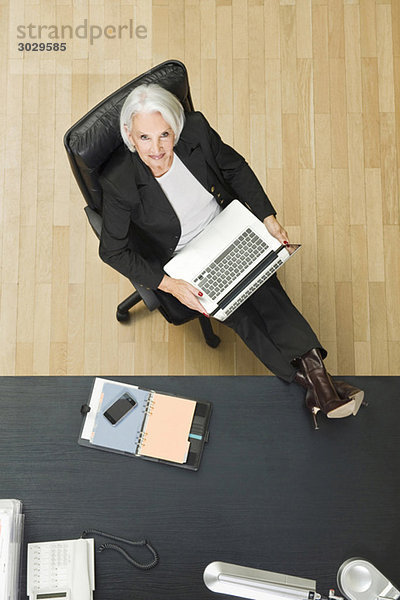 Senior Geschäftsfrau im Büro  mit Laptop  erhöhte Ansicht