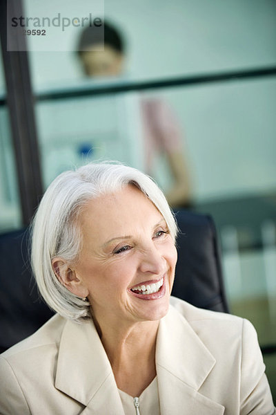Business woman laughing  colleague in background