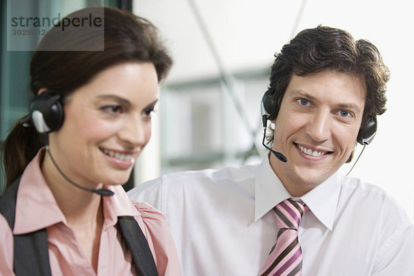 Germany  Munich  Co-workers wearing headsets