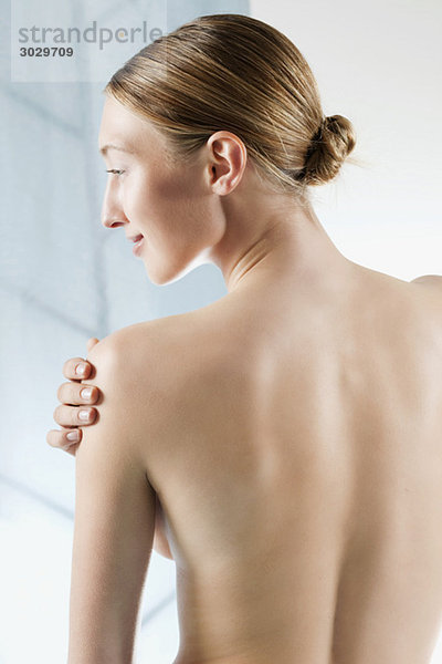 Rear view of woman  hand on bare shoulder