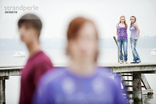 Zwei Frauen stehen auf dem Steg  Mann im Vordergrund