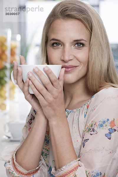 Junge Frau im Café mit einer Tasse Kaffee  Porträt  Nahaufnahme