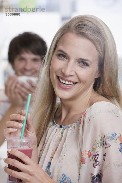 Junge Frau im Café  Mann im Hintergrund