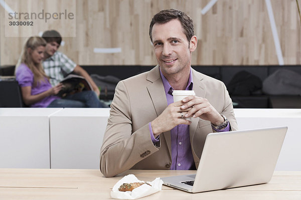 Geschäftsmann im Cafe mit Laptop