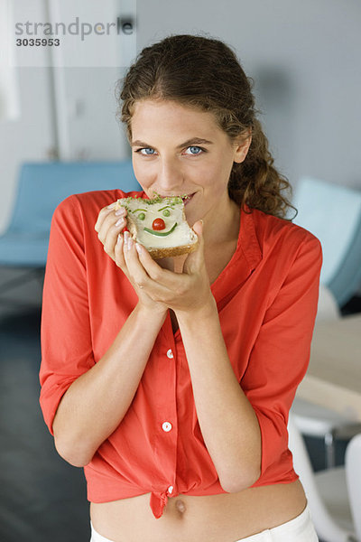 Porträt einer Frau beim Sandwichessen
