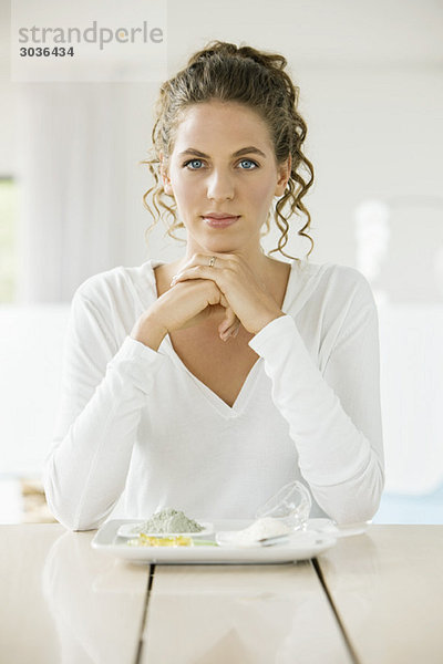 Porträt einer Frau am Tisch sitzend mit Tonen auf einem Teller