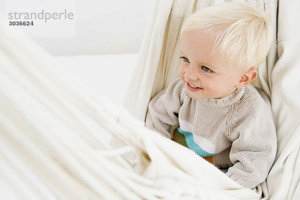 Baby Junge sitzt in einer Hängematte