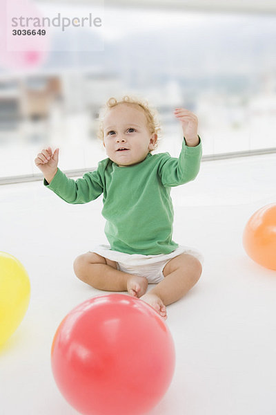 Baby Junge spielt mit Luftballons