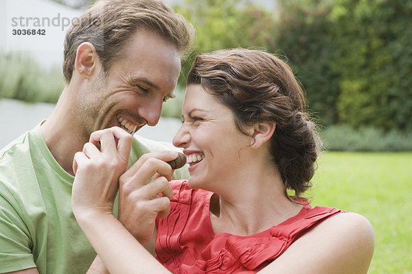 Paare füttern sich gegenseitig mit Schokolade und lächeln