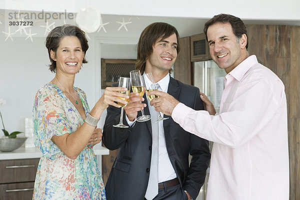 Mann und seine Eltern stoßen mit Champagner an.