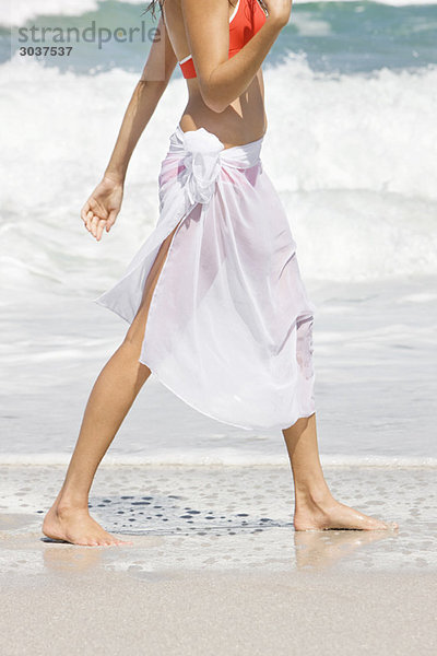 Flachschnittansicht einer am Strand spazierenden Frau