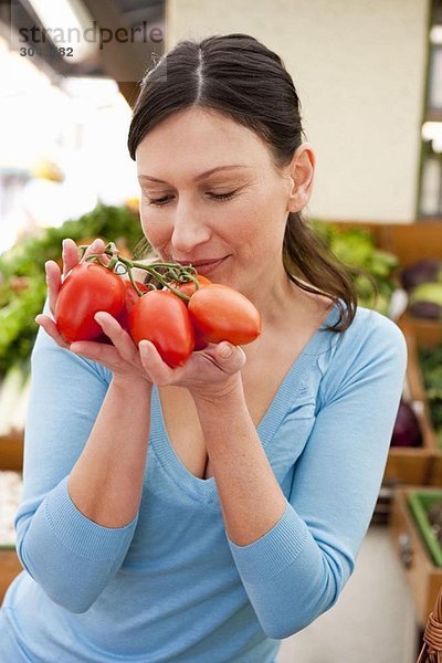 Frau riecht an frischen Tomaten