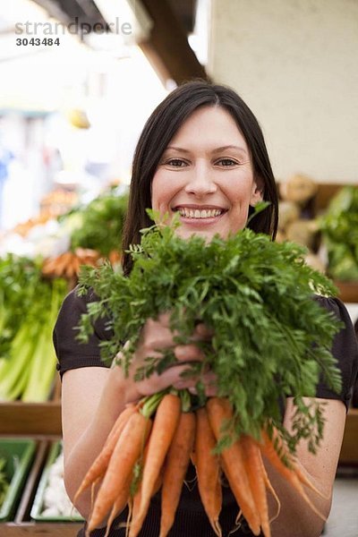 Frau mit Karottenbüschel