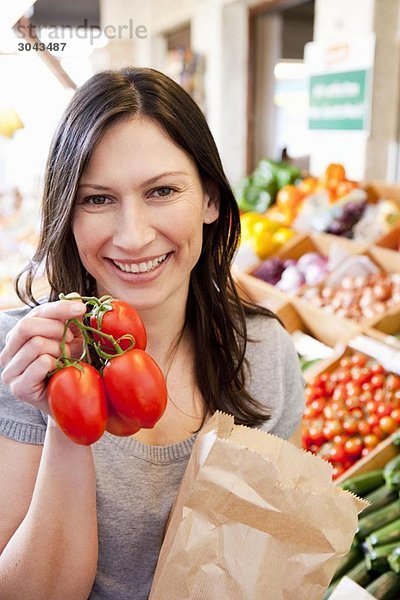 Frau zeigt frische Tomaten