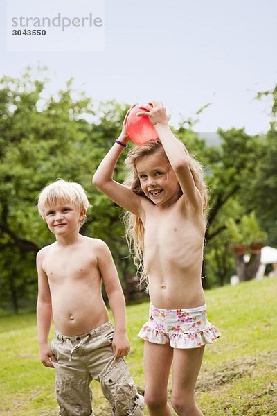 Junge und Mädchen spielen im Garten