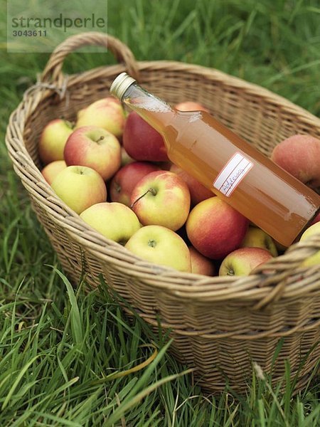 Äpfel im Korb mit Saftflasche