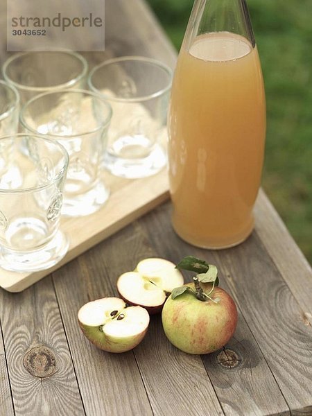 Äpfel  Apfelsaft und Gläser auf dem Tisch