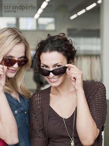 Frauen beim Einkaufen versuchen Sonnenbrille