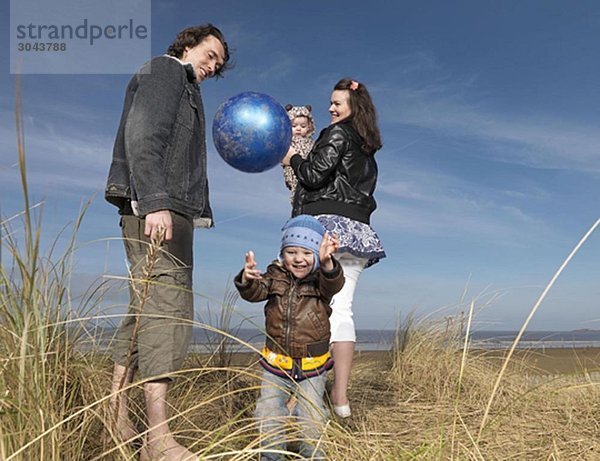 Familie am Strand beim Ballspielen