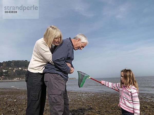 reifes Paar mit Kind am Strand